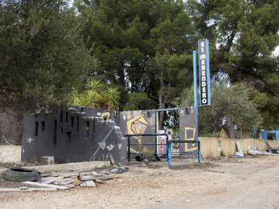 L'entrata del Merendero � segnalata da un'insegna verticale. Di fronte all'accesso, la cui porta � stata rubata, � ancora visibile la ringhiera piazzata per far rispettare la fila ai clienti, mentre a pochi passi notiamo un primo cumuli di detriti "coronato" da uno pneumatico sgonfio